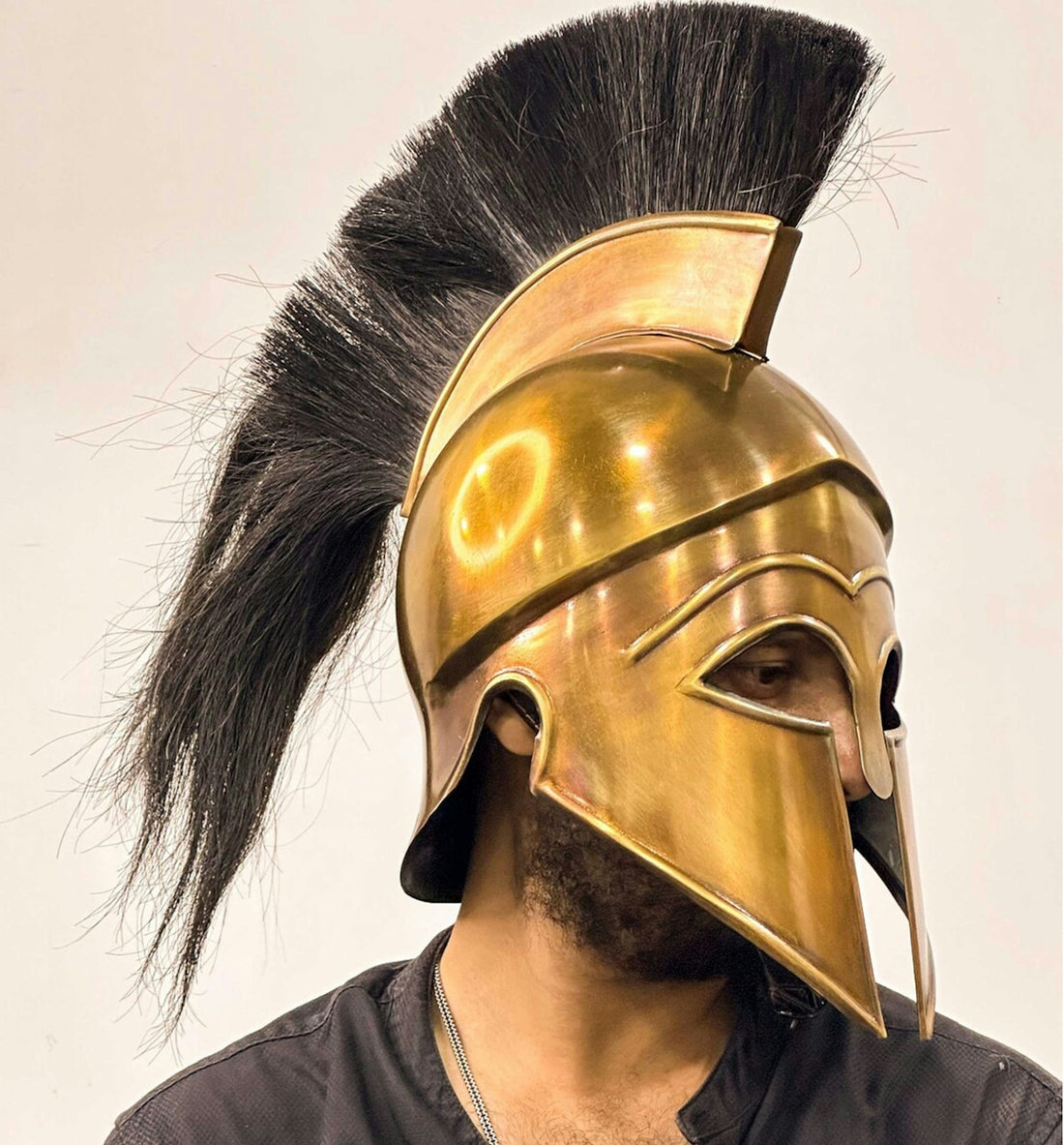 a man wearing a gold helmet with a black mohawk