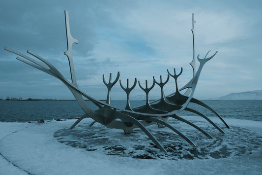 A boat sculpture sits on the shore.